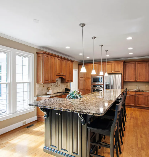 Kitchen before renovation with cherry cabinetry and a two-tier island.